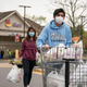 Hanna Vohra, 25, and Dylan Vohra, 17, carry bags to their car after shopping for groceries for senior citizens as part of Teens Helping Seniors.